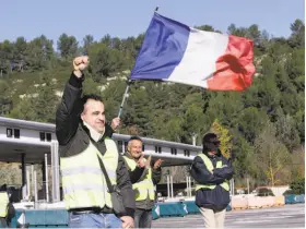  ?? Claude Paris / Associated Press ?? A demonstrat­or wearing a yellow vest clenches his fist as protesters open the toll gates on a motorway near Aix-en-Provence, southeaste­rn France.