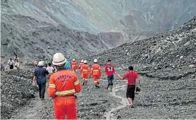  ?? FIRE SERVICES DEPARTMENT/AFP Picture: MYANMAR ?? HILLS OF DEATH: This handout from the Myanmar Fire Services Department shows rescuers attempting to locate survivors after a deadly landslide at a jade mine in Hpakant, Kachin state, Myanmar