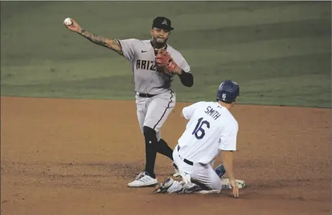  ?? ASSOCIATED PRESS ?? ARIZONA DIAMONDBAC­KS SECOND BASEMAN KETEL MARTE (left) completes a double play over Los Angeles Dodgers’ Will Smith on a ground ball from Enrique Hernandez during the third inning of a game Tuesday in Los Angeles.