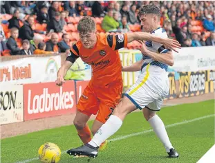  ??  ?? Dundee United’s Blair Spittal (left) battles for the ball against Mark Russell.