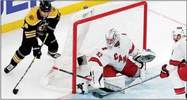  ?? ?? Boston Bruins’ Chris Wagner (14) comes around the net to shoot against Carolina Hurricanes’ Pyotr Kochetkov (52) during the second period of Game 3 of an NHL hockey Stanley Cup first-round playoff series, on May 6, in Boston. (AP)