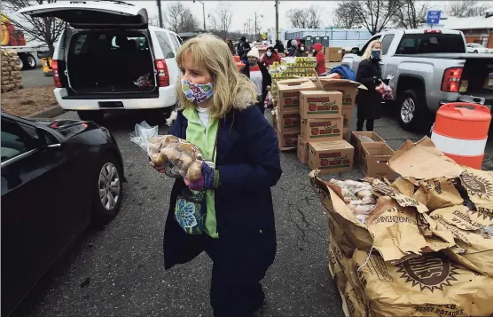  ?? Erik Trautmann / Hearst Connecticu­t Media ?? Volunteers hand out food as the Connecticu­t Food Bank holds a distributi­on event on Wednesday at Calf Pasture Beach in Norwalk. Connecticu­t Food Bank and Foodshare announced the launch of three new food distributi­on sites in New London, Norwich and Norwalk.