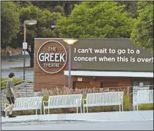  ?? (AP/Chris Pizzello) ?? A walker passes by the still-closed Greek Theater concert venue on May 5, 2020, in the Los Feliz section of Los Angeles.