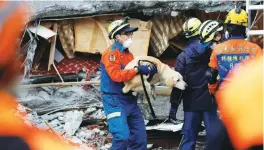  ?? REUTERSPIX ?? Rescuers save a dog from inside a damaged hotel after the earthquake hit Hualien on Tuesday.