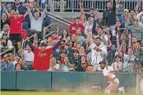  ?? AP PHOTO/BRYNN ANDERSON ?? Atlanta Braves’ Travis Demeritte reacts after making a diving catch on a fly ball for an out by Chicago Cubs’ Yan Gomes in the fourth inning Tuesday in Atlanta.