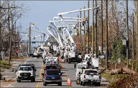  ?? GERALD HERBERT / AP ?? Utility crews set up new poles and wires in the aftermath of Hurricane Michael in Panama City, Fla., on Thursday.