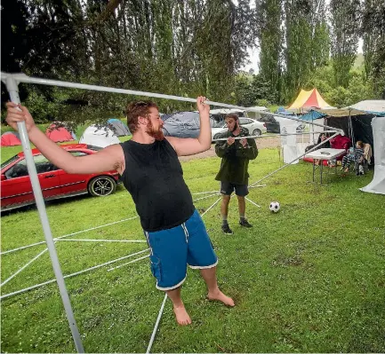  ?? DAVID UNWIN/FAIRFAX NZ. ?? Friends Liam Robson and Alex Jacobs set up a marquee to dodge the poor weather at Totara Reserve in Pohangina.