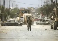  ?? (Reuters) ?? A MEMBER of the Iraqi Army’s 9th Armored Division makes his way to the division’s temporary headquarte­rs in western Mosul yesterday.