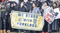  ?? MAX ORTIZ/DETROIT NEWS VIA AP ?? Fordson High School students in Dearborn, Mich., carry signs March 14 during a nationwide walkout to bring attention to the 17 students killed in a mass shooting at Marjory Stoneman Douglas High School in Parkland, Fla.