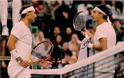  ?? LAPRESSE ?? Il confronto a rete
Rafael Nadal, 36 anni, a sinistra e Lorenzo Sonego, 27, discutono dopo che lo spagnolo si è lamentato delle urla dell’italoano a scambio in corso. Rafa ha vinto Wimbledon nel 2008 e nel 2010: per la prima volta nella carriera è al terzo Slam della stagione dopo aver vinto i primi due