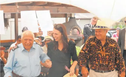  ?? Photos / Peter de Graaf ?? Top: Yvonne Rapana waves the flag of the United Tribes of Aotearoa in a salute to the waka Taiamai. Above: Jacinda Ardern, the first Prime Minister to visit the Ma¯ori wardens, escorts warden Henare Hape.