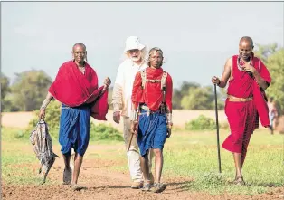  ?? COLETTE PHILLIPS ?? Alistair Bath walks with Maasai men in Kenya. Bath has worked with them to help protect not only their valuable cattle, but also the lions which are a threat to the cattle.