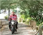  ??  ?? BUTUH PELEBARAN: Pengendara sepeda motor melintasi akses yang masih sempit menuju Hutan Kota Pakal.