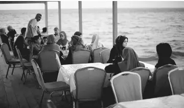  ??  ?? Palestinia­ns sit abroad ‘Lolo Rose’ ship which has become a popular restaurant, on a beach in Gaza City. — Reuters photo