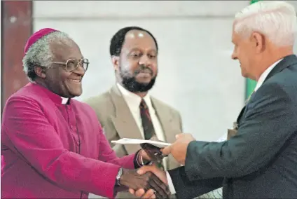  ?? Photo: Anna Zieminski/afp ?? Witness: The TRC’S investigat­ive unit head, Dumisa Ntsebeza (centre), watches as Freedom Front leader Constand Viljoen (right) hands his party’s submission to Archbishop Desmond Tutu.