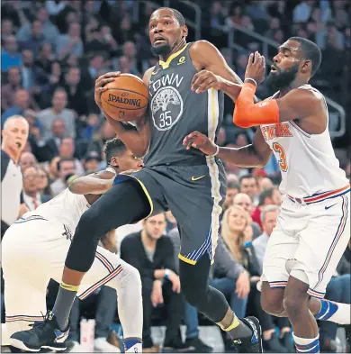  ?? PHOTOS: KATHY WILLENS — THE ASSOCIATED PRESS ?? Warriors forward Kevin Durant collides with New York guard Frank Ntilikina, left, and forward Tim Hardaway Jr. during the first half.