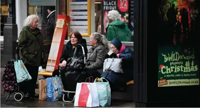  ?? ?? Women at a bus stop after shopping in Chester.
UK inflation accelerate­d to a 41-year high of 11.1 per cent in October. - afp