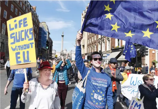  ??  ?? Demonstrat­ors hold placards and wave EU flags during an anti-Brexit, pro-EU march in London on March 25. (AFP)