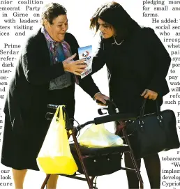  ??  ?? TDP candidate Ayşe Öztabay hands a party brochure to an elderly woman in the street