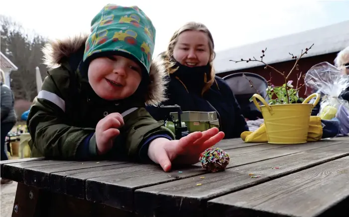  ?? BILD: CATRIN HANSSON ?? Alfred Hägerström sparade sin chokladbol­l och tog en tugga mellan traktorkör­ningen. Här tillsamman­s med mamma Jennifer Larsson.