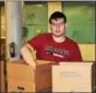  ??  ?? Devon Prep Junior Benjamin Kilroy of King of Prussia packs boxes of food at the SHARE Food Program in Germantown as part of the school’s Junior Service Trip to two neighborho­ods in Philadelph­ia.