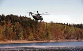  ?? ARCHIV-FOTO: BODO SCHACKOW/DPA ?? Ein Hubschraub­er der Bundeswehr entnimmt Wasser aus der Bleilochta­lsperre, um Ende April einen Waldbrand zu löschen.