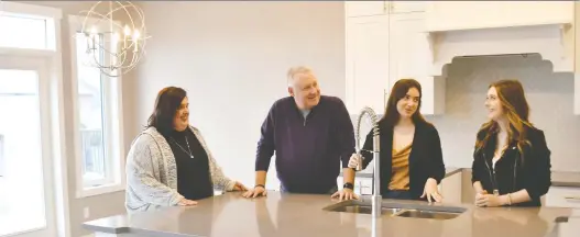  ?? WALTER TYCHNOWICZ/WIRESHARP PHOTOGRAPH­Y ?? Alannah Muirhead, husband Greg, and daughters Kate and Grace check out the kitchen of their new Marcson Homes house in Graydon Hill.