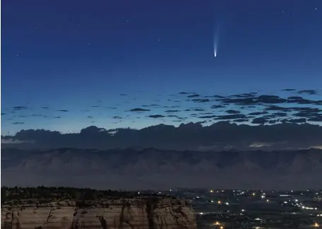  ?? Ap pHOTOS ?? MAKING A SCENE: Comet Neowise soars in the horizon of the early morning sky in this view from the near the grand view lookout at the Colorado National Monument west of Grand Junction, Colo., on Thursday. The newly discovered comet is streaking past Earth, providing a celestial nighttime show after buzzing the sun and expanding its tail.