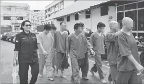  ??  ?? The suspects being led to Miri Central Police Station yesterday.