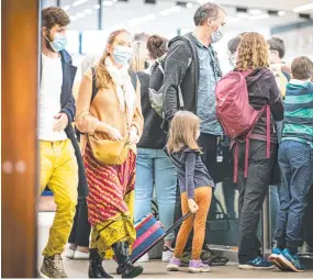  ?? Picture: Mathew Farrell ?? Visitors to Tasmania wearing masks upon arrival at Hobart Airport.