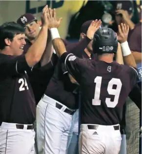  ?? (Photo by Gerald Herbert, AP) ?? Mississipp­i State's Brent Rooker (19) is greeted at the dugout after scoring on a basesloade­d walk in the first inning of Saturday night's game against LSU. Rooker headlines a list of Bulldogs that could be drafted as the Major League Baseball Draft...