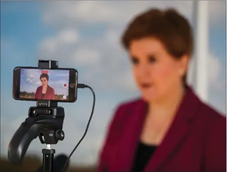  ?? Picture: Russell Cheyne/pa ?? First Minister Nicola Sturgeon on a mobile phone screen as she speaks ahead of her big speech today at the SNP conference