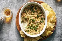 ?? MALOSH/THE NEW YORK TIMES FOOD STYLIST: SIMON ANDREWS. DAVID ?? Spicy clam dip with potato chips in New York on May 12. This revamped 1950s staple, a celebratio­n of canned clams, takes some cues from rich, cheesy crab dip.
