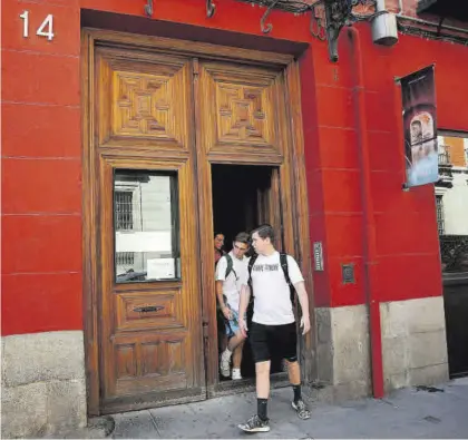  ?? Turísticos en el centro de Madrid. JOSÉ LUIS ROCA ?? Unos jóvenes salen de un inmueble de pisos