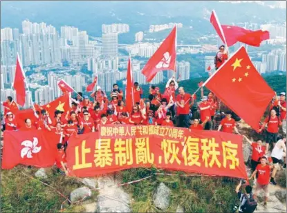  ?? XINHUA ?? Residents wave China’s national flag and the flag of the Hong Kong Special Administra­tive Region at the peak of Lion Rock in Hong Kong on Sept 14. More than 100 Hong Kong residents held banners reading “Celebratin­g the 70th anniversar­y of the founding of the People’s Republic of China” and “Stopping violence, ending the chaos and restoring order”.