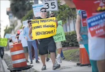  ?? Joe Raedle Getty Images ?? PROTESTERS march in Fort Lauderdale, Fla., last year to demand universal health coverage. Democrats’ developing strategy aims to capitalize on the overwhelmi­ng popularity of Medicaid and Medicare.