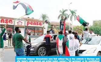  ?? —AFP ?? KHARTOUM: Sudanese demonstrat­ors wave their national flag as they celebrate in Khartoum early after Sudan’s ruling generals and protest leaders reached a ‘full agreement’ on the constituti­onal declaratio­n.