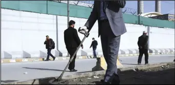  ?? ASSOCIATED PRESS ?? An Afghan security official looks March 17 for mines or improvised explosive device with metal detector on a roadside during a trip organized by the police for The Associated Press, in Kabul, Afghanista­n.