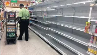  ?? LEILA MACOR/AFP/GETTY IMAGES ?? Empty water shelves such as these in a Miami Beach supermarke­t have quickly become a familiar sight in South Florida. Retailers say more essential supplies are on the way.