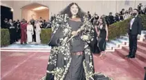  ?? EVAN AGOSTINI/ INVISION ?? Lizzo played her gold flute as she walked the red carpet May2ina look by Thom Browne at the Metropolit­an Museum of Art’s Costume Institute benefit gala.