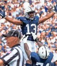  ?? DAN RAINVILLE/USA TODAY NETWORK ?? Penn State running back Kaytron Allen, center, celebrates his first touchdown of the season with offensive lineman Olu Fashanu during the first quarter against Delaware on Saturday.