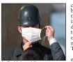  ?? (AP/Burhan Ozbilici) ?? A Turkish soldier adjusts a comrade’s mask Tuesday in Ankara before a ceremony at the mausoleum of Mustafa Kemal Ataturk, the founder of modern Turkey.