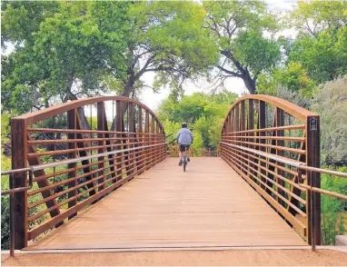  ?? JIM THOMPSON/JOURNAL ?? A lone bicyclist rides across the Atrisco Siphon Bridge on Tuesday as city officials and members of the community welcomed the completion of an ADA-accessible trail through the bosque. The two-year project cost $2 million.