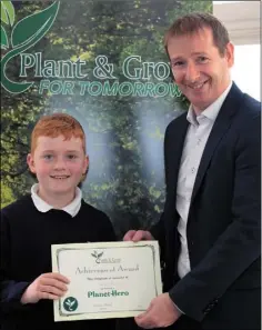  ??  ?? Steven McGinley from Tombrack National School receives his Planet Hero certificat­e from Laurence Kinsella.