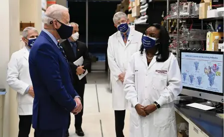  ?? SAUL LOEB TNS ?? In February, President Joe Biden listened to Dr. Kizzmekia Corbett, right, while touring the Viral Pathogenes­is Laboratory at the National Institutes of Health in Bethesda, Maryland.