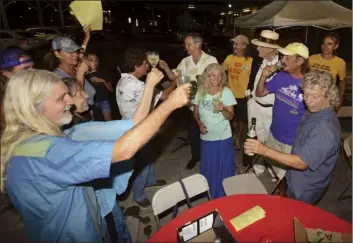  ?? The Maui News / MATTHEW THAYER photo ?? Happy Pono Network supporters toast after the third printout results were announced Tuesday at Akaku Maui Community Media’s election night block party in Kahului. ‘Ohana Coalition-backed candidates took five of nine council seats and are in position to elect a council chairman or chairwoman.