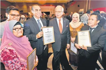  ??  ?? Najib poses with representa­tives of GLCs after the presentati­on of certificat­e of appreciati­on. — Bernama photo
