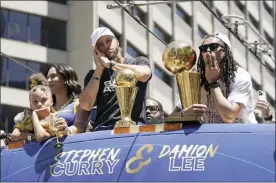  ?? AP photo ?? Stephen Curry and Damion Lee ride atop a bus during the Warriors’ championsh­ip parade in San Francisco on Monday.