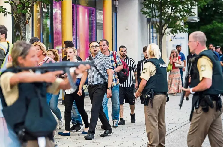  ?? — AFP ?? Eyes wide open: Police evacuating people from the shopping mall following the shootings in Munich.