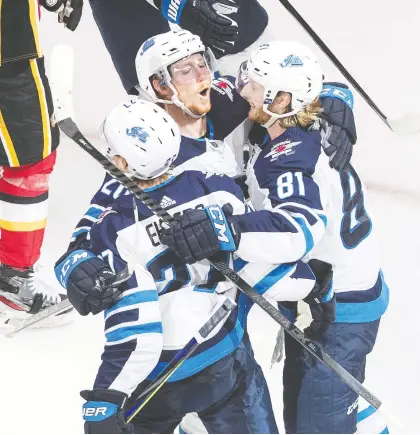  ?? JASON FRANSON/THE CANADIAN PRESS ?? The Jets celebrate after Nikolaj Ehlers scored a third-period goal against the Calgary Flames on Monday.